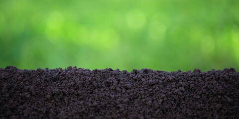 soil against the background of blurred plants, pile of fertile ground