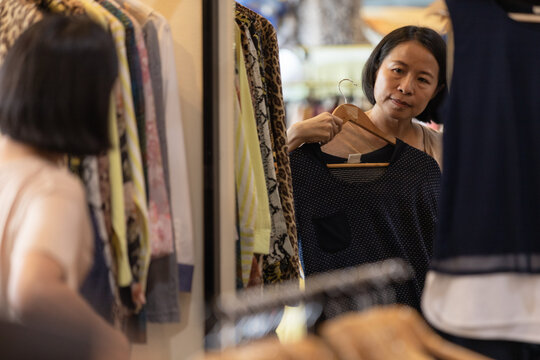 Asian woman choosing clothes in a local boutique shop