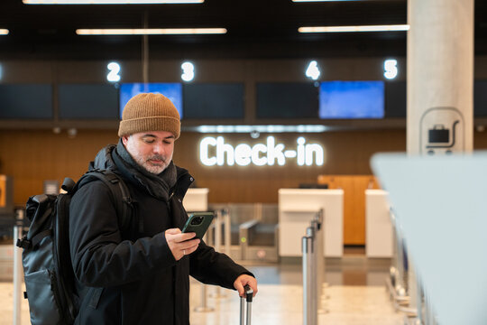 Man Checking Flight Details at a Modern Airport 