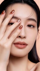 指先を顔に添えたブラウンネイルと印象的な瞳