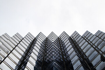 Landscapes skyscraper building window glass top with sky white clouds and bright sunlight is background. Large building structure in business district in big city. Architecture of construction.