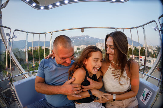 Laughing family enjoys the ferris wheel ride