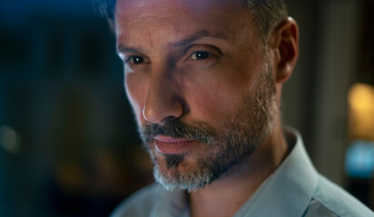 Mature man thinking with serious expression in dramatic lighting
