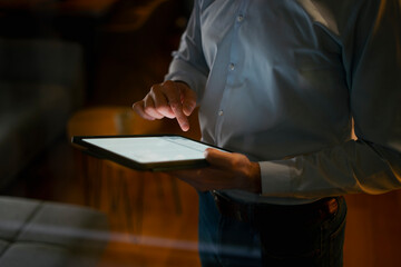 Businessman using digital tablet touching screen at night