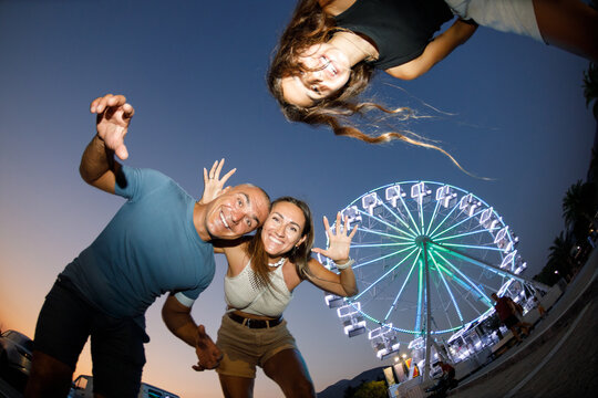 Family fooling around by the ferris wheel