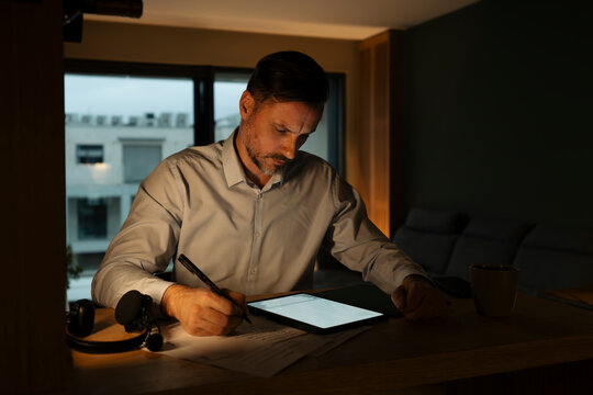 Man working late night at home office desk
