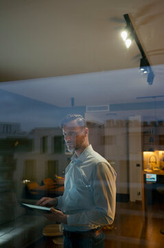 Man controlling smart home system using digital tablet
