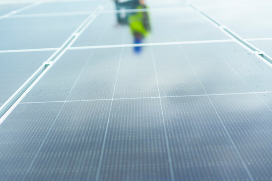 Worker performing maintenance on clean energy solar panels
