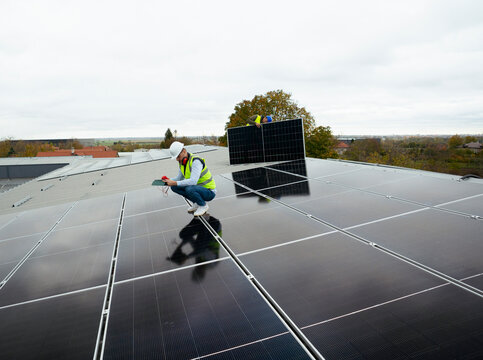 Engineer performing inspection of solar panels on roof

