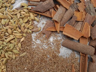Green cardamom pods, cinnamon bark,  and whole cumin seeds flavor seasoning ingredient spice. Delicious Culinary dry spices as cardamom,  cinnamon, and cumin. 