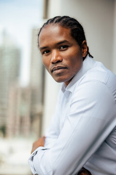 Confident Man With Cornrows In Light Blue Shirt 