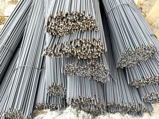 Close-up texture of bundled ribbed steel rebar rods stacked high