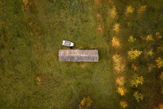 Rustic Shed Beside a Small Boat in a Lush Green Field