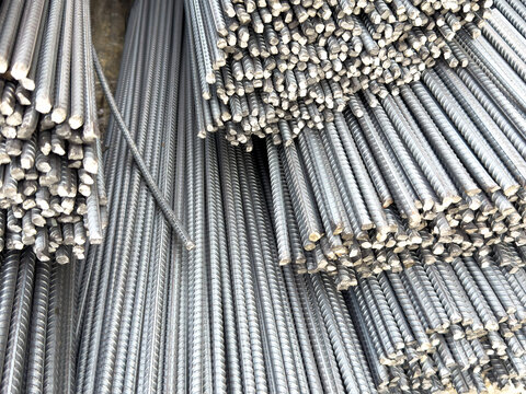 Close-up texture of bundled ribbed steel rebar rods stacked high