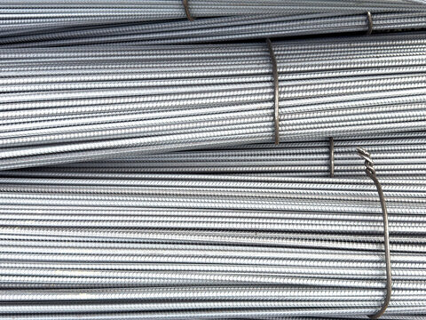 Close-up texture of bundled ribbed steel rebar rods stacked high