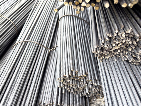 Close-up texture of bundled ribbed steel rebar rods stacked high