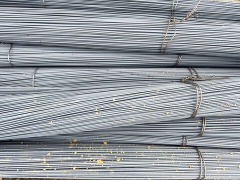 Close-up texture of bundled ribbed steel rebar rods stacked high