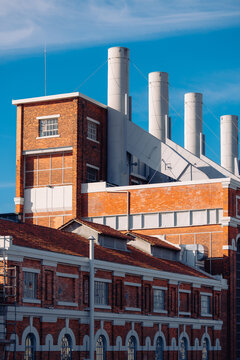 Historic Industrial Building With Smokestacks in Blue Sky