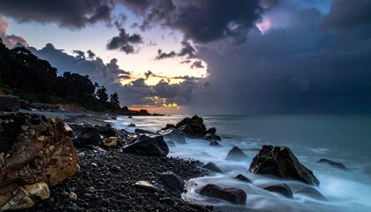 Obraz premium Dramatic Coastal Scene - Cloudy Sky, Rocky Shoreline, and Ocean Waves.