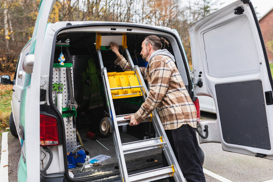 Tradesman Folding and Stowing Ladder in Service Van