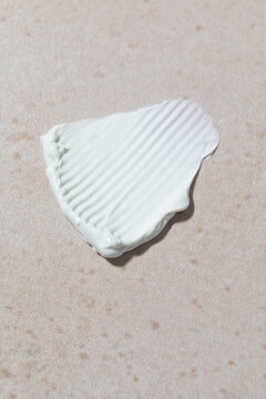 Pale Blue Cosmetic Cream on a Beige Surface Showing Distinct Textures