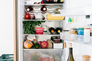An open fridge interior displaying assorted containers