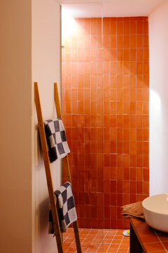 A bathroom decorated with ceramic tiles, illuminated by sunlight