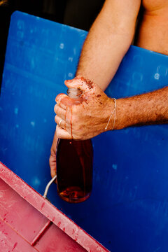 Winemaker hands venting gas from a sparkling wine bottle