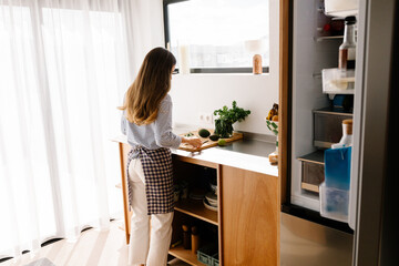 Woman enjoying a relaxed moment inside while making food