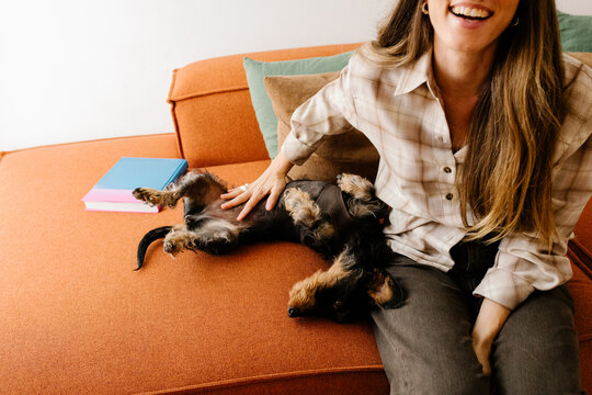 Woman enjoying quality time with her dog on a sofa at home