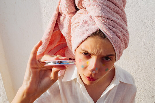 A pre-teen stuck many pimple patches in the shape of colorful stars