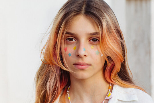 A pre-teen stuck many pimple patches in the shape of colorful stars