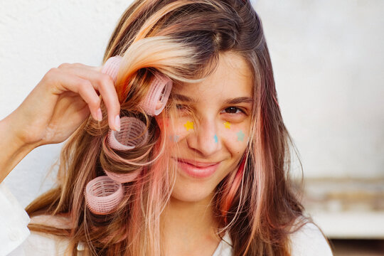 A girl stuck lots of pimple patches and put in curlers.