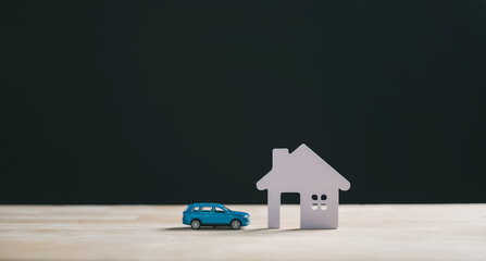 Home property, car loan, real estate, house insurance concept depicts new dwelling plans, miniature blue automobile on wood desk, future business investment