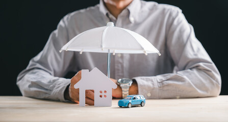 Businessman presents home car insurance concept, offering house and auto coverage for family life health business assets, umbrella provides security and protection