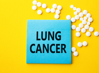 Lung Cancer symbol. Concept word Lung Cancer on blue note. Beautiful yellow background with pills. Medicine and Lung Cancer concept. Copy space