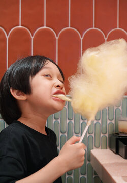 Chinese boy enjoys a cotton candy at home