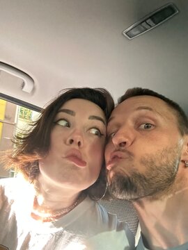 A selfie of a young, funny couple making faces at the camera
