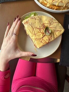 a large piece of cheeseburger compared to a hand