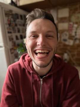A young handsome man laughs loudly with his teeth. ugc