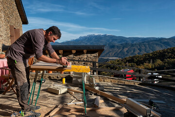 Woodworker working outside, a rural house