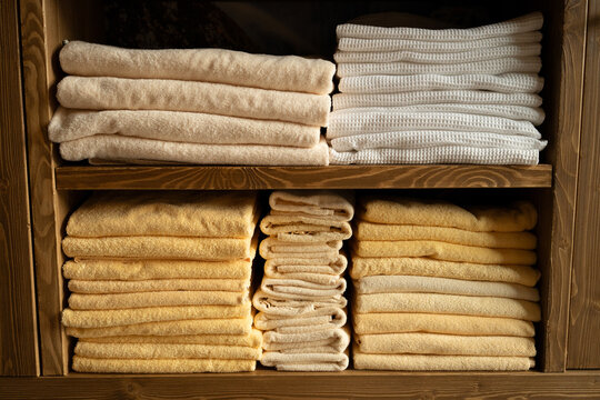 Stacked towels on wooden shelves  
