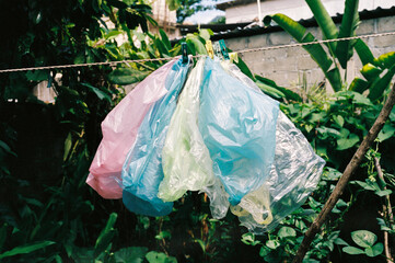 Film photo of a colorful Plastic Bags Hanging in a Lush Garden