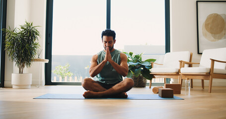 Yoga, meditation and man in home, namaste and mindfulness for inner peace, calm and wellness on mat. Zen, person and spiritual awareness for mental health, yogi and prayer hands for stress relief