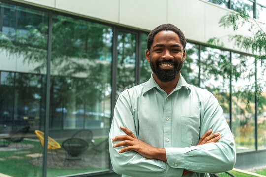 Confident Male Professional Smiling Outdoors Near Modern Building