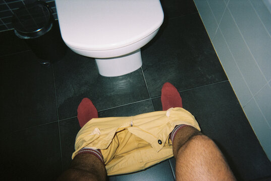seen from above, a man sitting in front of a bidet, 35mm film