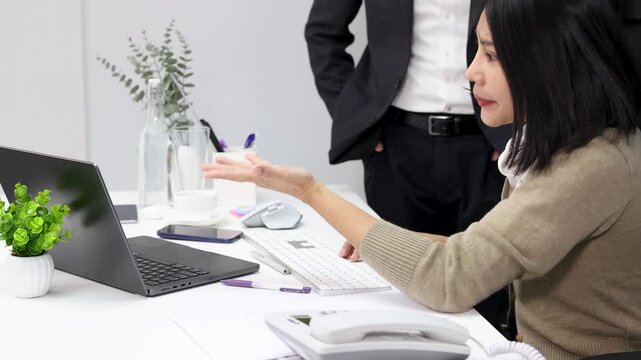Asian Businesswoman Having Intense Discussion With Male Coworker in Office