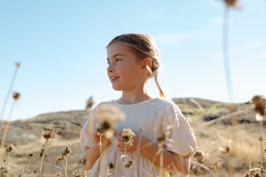 Candid portrait of a young girl in a sunny field