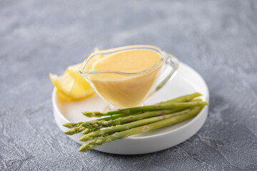 Homemade yellow hollandaise sauce in glass bowl. Traditional Dip for Asparagus and fish