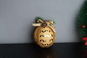 Christmas gift boxes with red and green ribbon, wreath garland, candy cane, santa sock, bauble and golden bells on black wooden table. Blank background mockup with copy space for adding text